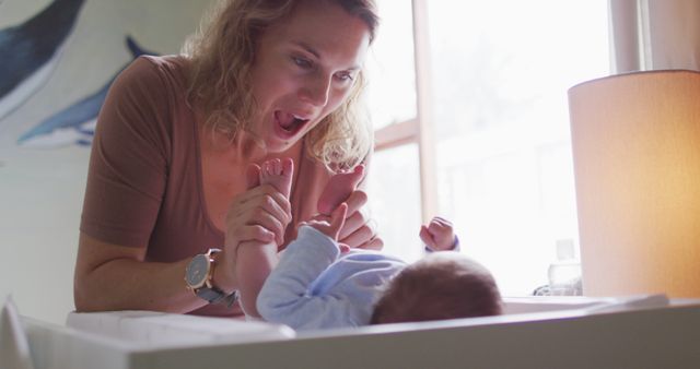 Mother in a brightly lit nursery changing her baby's diaper. Ideal for use in parenting articles, baby care advertisements, and family-related content focusing on bonding between mother and child.