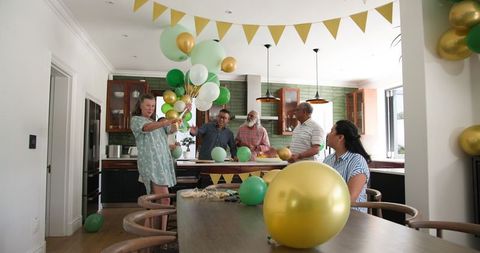 Senior friends preparing home with balloons for celebration party