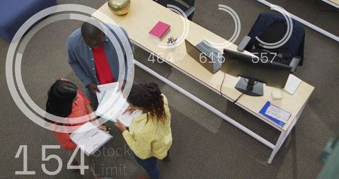 Overhead Office Team Collaborating on Reports and Tablet Near Modern Workstation