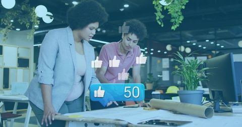 Creative Team in Studio Reviewing Architectural Plans with Social Media Concept