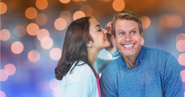 Woman smiling while whispering in a man's ear, creating a sense of intimacy and happiness. Fading bokeh lights offer festive atmosphere, suitable for relationship advice, communication tips, holiday greeting cards or ads highlighting couple's activities.