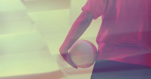 Woman Holding Volleyball in Dynamic Pink-Lit Gym