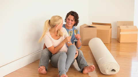 Couple Toasting Satisfaction in New Home