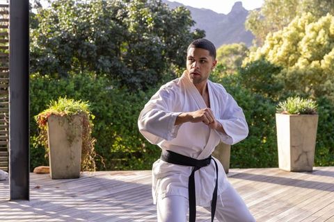 African american martial artist training outside in white gi and black belt