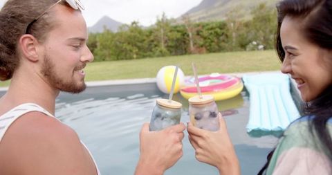 Couple Enjoying Drinks by Poolside on Relaxing Summer Day