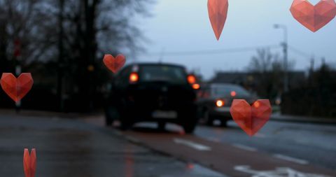 Falling Red Hearts Amidst Urban Road Traffic