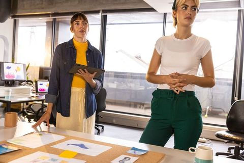 Creative female coworkers discussing design concepts in modern office