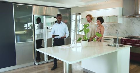 Diverse Young Couple Touring Modern Kitchen with Real Estate Agent