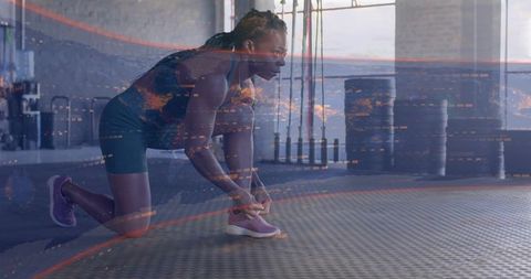 Kneeling woman tying purple running shoe with digital data overlay in urban gym studio