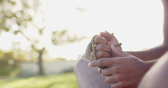 Person Holding Prayer Beads Outdoors at Sunset, Practicing Mindfulness - Download Free Stock Images Pikwizard.com