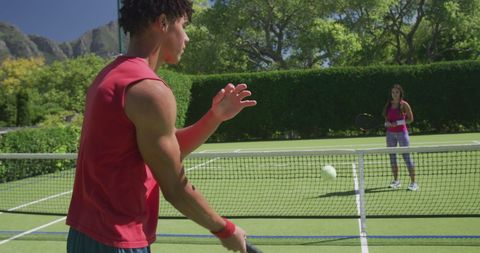 Happy Couple Enjoying Game of Tennis Outdoors on Sunny Day