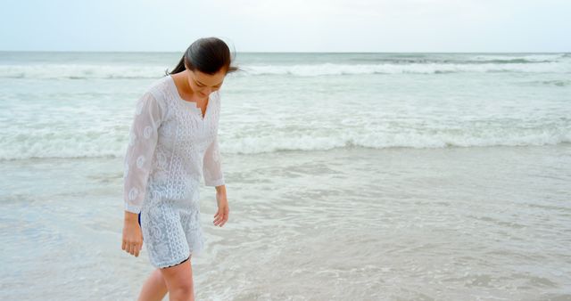 Young Woman Walking Along Seashore on Peaceful Beach - Download Free Stock Images Pikwizard.com