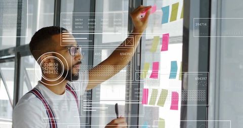 Young professional engaging in creative planning with tech overlays