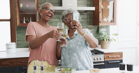 Senior African American Friends Enjoying Wine and Taking Selfies