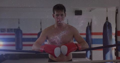 Leaning bare-chested boxer radiating focus and strength with red gloves and cosmic overlay