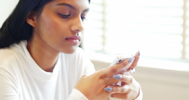 Young Woman Using Smartphone for Communication in Bright Room - Download Free Stock Images Pikwizard.com