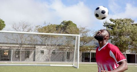 Athlete in Red Jersey Practicing Soccer Heading Techniques Outdoors