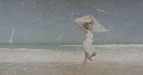 Woman Dancing Freely on Sandy Beach