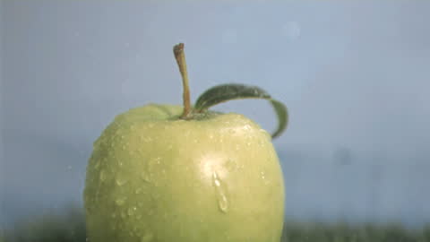 Refreshing Green Apple Getting Sprinkled with Water in Slow Motion