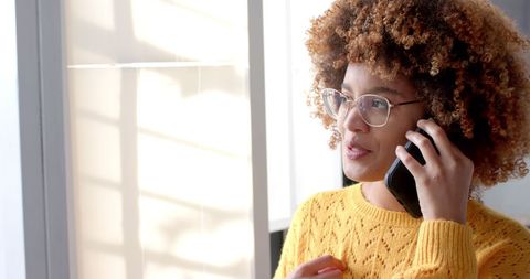 Businesswoman Engaged in Phone Call Near Office Workstation