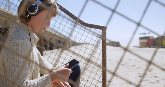 Young Adult Listening to Music on Beach - Download Free Stock Images Pikwizard.com