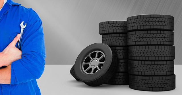 The image showcases a mechanic in a blue uniform holding a wrench with stacks of car tires in the background. Ideal for illustrating car repair services, automotive workshops, and maintenance-related themes. Can be used in advertisements, brochures, and websites for automotive repair shops, tire retailers, and mechanical training courses.