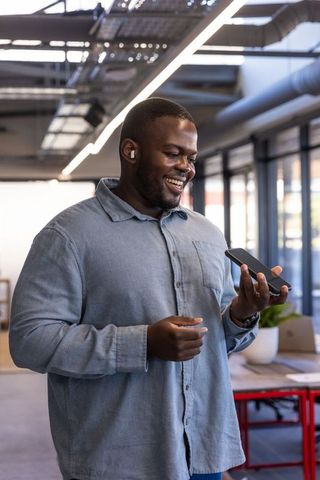 African american professional enjoying communication in modern office with smartphone