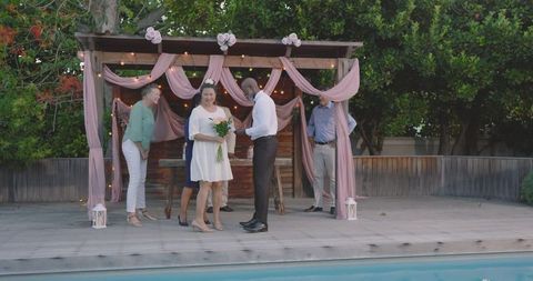 Senior couple exchanging vows in intimate backyard ceremony