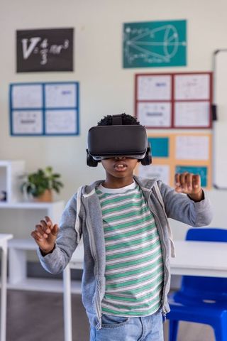 African american boy using vr headset for immersive stem learning in classroom