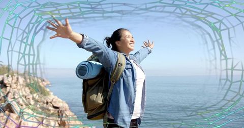 Adventurous Woman Embracing Freedom on Rocky Cliff by Sea