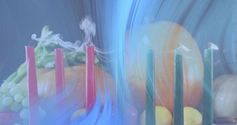 Smoldering taper candles with autumn fruit still life and blue light motion blur