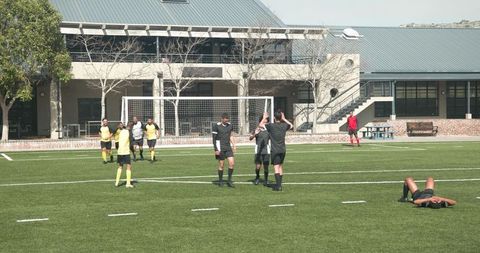 Youth Soccer Players Celebrating Winning Goal on Sunny Day