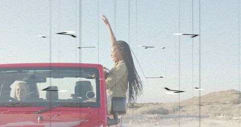 Two Friends Celebrating Adventure in Red SUV on Desert Road