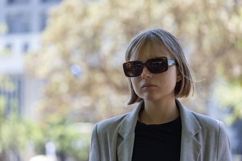 Urban chic woman wearing tortoiseshell sunglasses and grey blazer modern street-style headshot