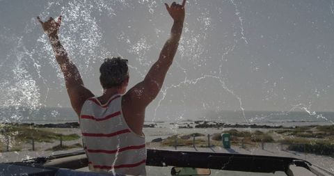 Man celebrating freedom parked on scenic oceanfront