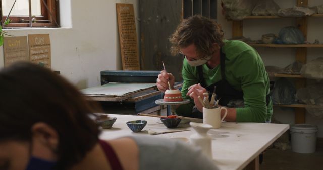 Focused Pottery Artist Painting Ceramic Bowl in Craft Studio - Download Free Stock Images Pikwizard.com