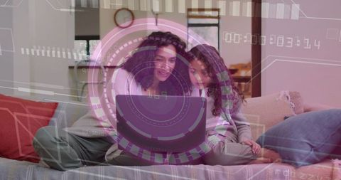 Mother and daughter using laptop on cozy sofa, learning together with tech HUD overlay