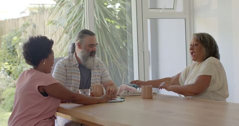 Senior Couple and Friend Enjoy Leisurely Dining Table Chat