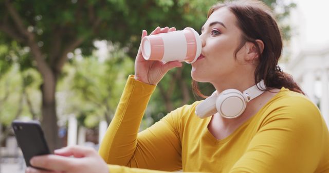 Young Woman Drinking Coffee and Using Smartphone in Park - Download Free Stock Images Pikwizard.com