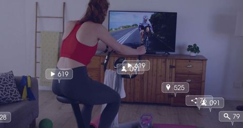 Woman Engaged in Virtual Cycling Workout at Home with Leaderboard Icons