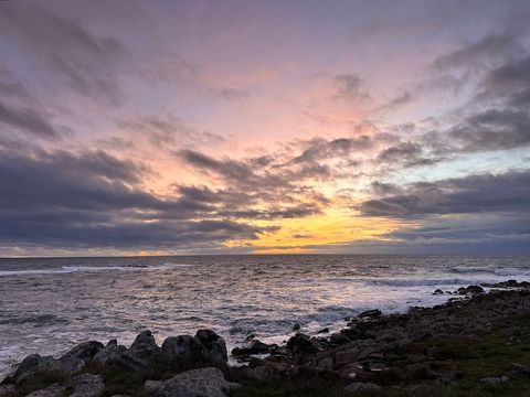 Serene beach sunset with colorful sky and rocky shoreline