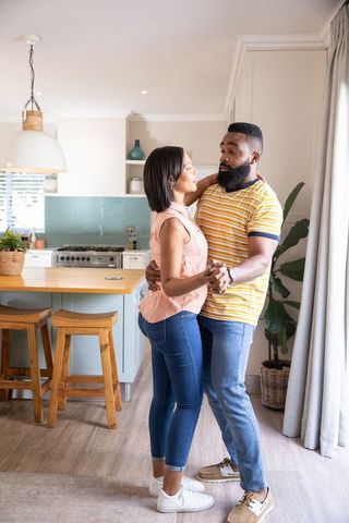 Joyful Couple Dancing in Modern Kitchen Under Cozy Lighting
