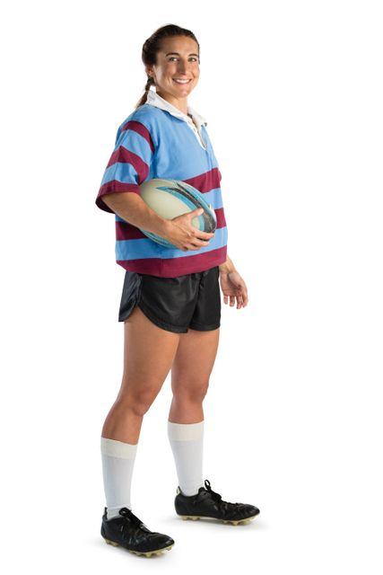 Full length portrait of happy young female player with rugby ball while standing against white background