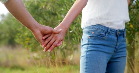 Couple Holding Hands Outdoors Highlighting Connection