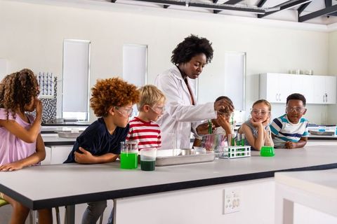 African american teacher leads elementary students in hands-on chemistry experiment