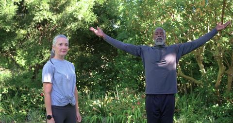 Seniors practicing morning breathwork and gentle stretching in sunlit garden