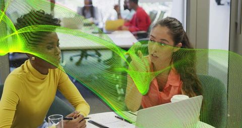 Korean woman gesturing during coworking collaboration with colleague in modern workspace