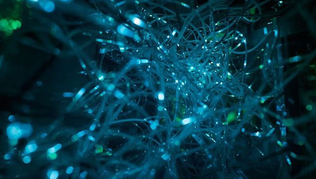 Glowing teal fiber optic strands forming futuristic abstract network of light and data