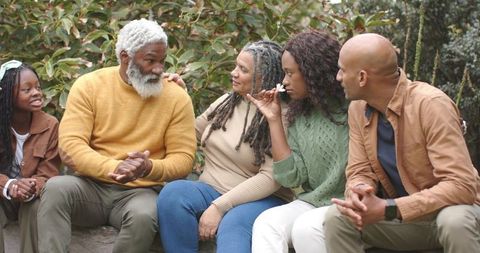Multigenerational african american family sitting together outdoors sharing quiet moment