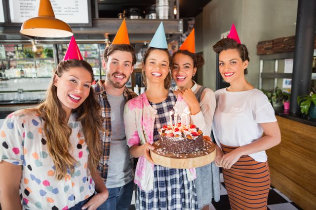 Portrait of cheerful friends celebrating birthday at restaurant